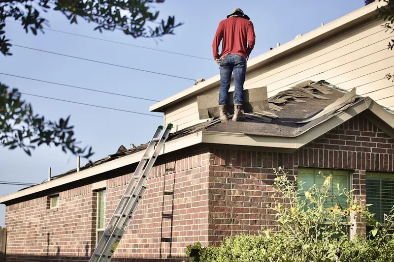 Professional roofer working on a residential roof in Woodward